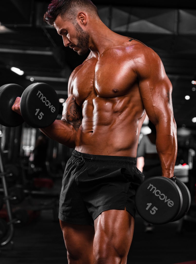 fit young man training arms in gym