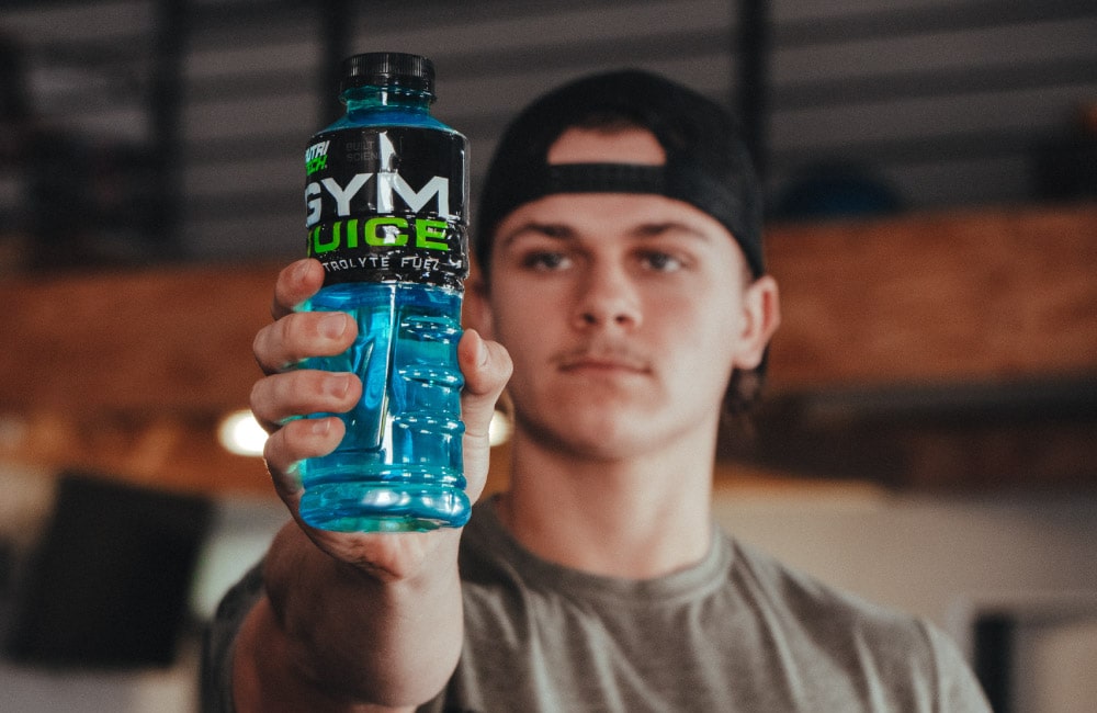 young male holding nutritech gym juice electrolyte drink